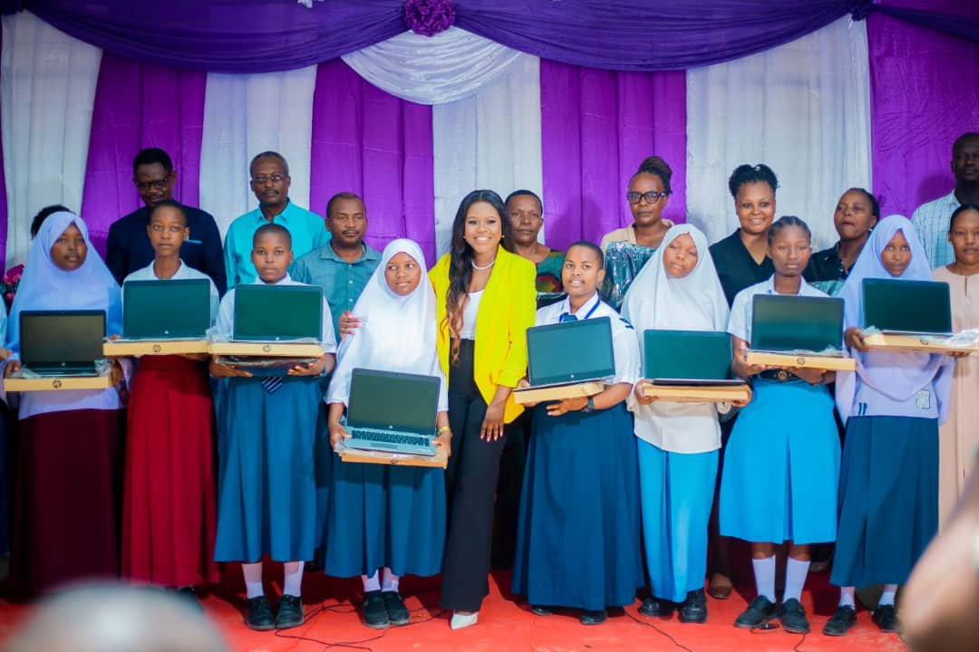 Her Initiative Executive Director Lydia Charles handing over laptops to Mshiko Club Girls