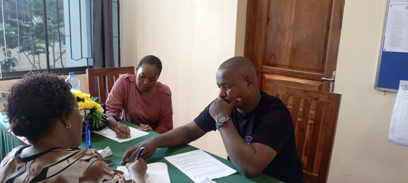 Mshiko Club teachers signing the documents on behalf of the students